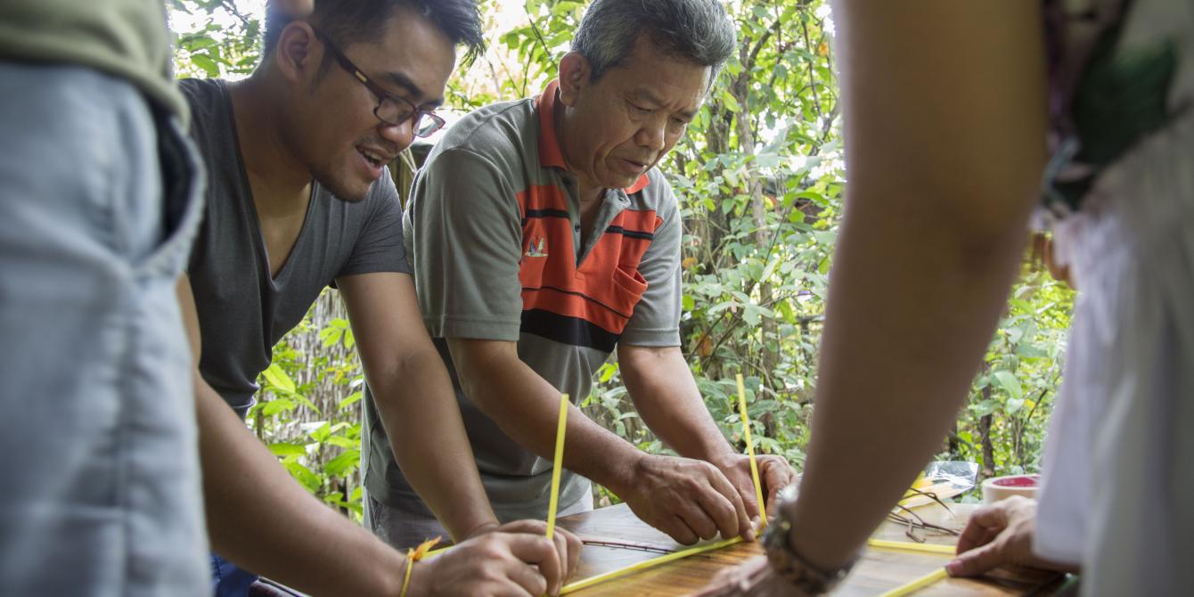 La (grey-orange shirt) works in a group, part of team building game, during annual program reflection in Tatai, Koh Kong, 2017. Photo: Seiha Tiep/Oxfam. La (grey-orange shirt) works in a group, part of team building game, during annual program reflection in Tatai, Koh Kong, 2017. Photo: Seiha Tiep/Oxfam.