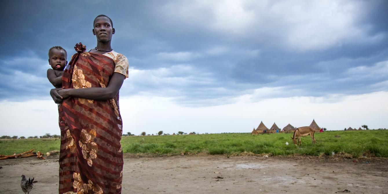 Tahrir holds her baby outside her house in Pading county in Jonglei State where Oxfam distributes food to displaced families. Albert González Farran/Oxfam