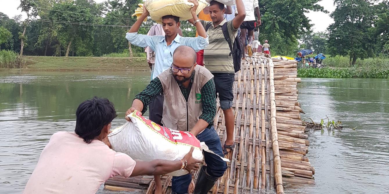 Oxfam staff handing food supplies to the people affected by 2017 floods in Sarlahi district. Photo credit: BWSN Oxfam staff handing food supplies to the people affected by 2017 floods in Sarlahi district. Photo credit: BWSN