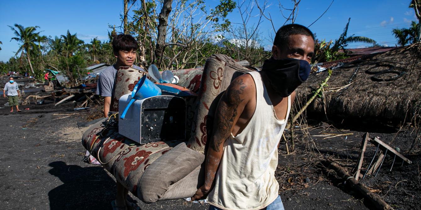 Kenneth*, a 14-year-old resident of San Francisco village in Guinobatan town in the province of Albay helps in carrying the things they salvaged from their destroyed house due to a lahar flow. On 1 November 2020, hundreds of houses in two villages in Guinobatan town were buried when rainwater mixed with volcanic debris, which was as high as 15 feet, came rushing down from the slope of Mayon Volcano at the height of Super Typhoon Rolly. (Photo: Mark Saludes/Oxfam)