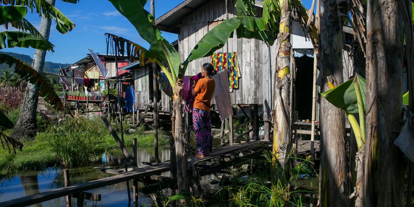 A woman doing her chores on a makeshift bridge that connects her home in a flood-prone area in Barangay Tamontaka 4 in Cotabato City. (Photo: Manman Dejeto/Oxfam)