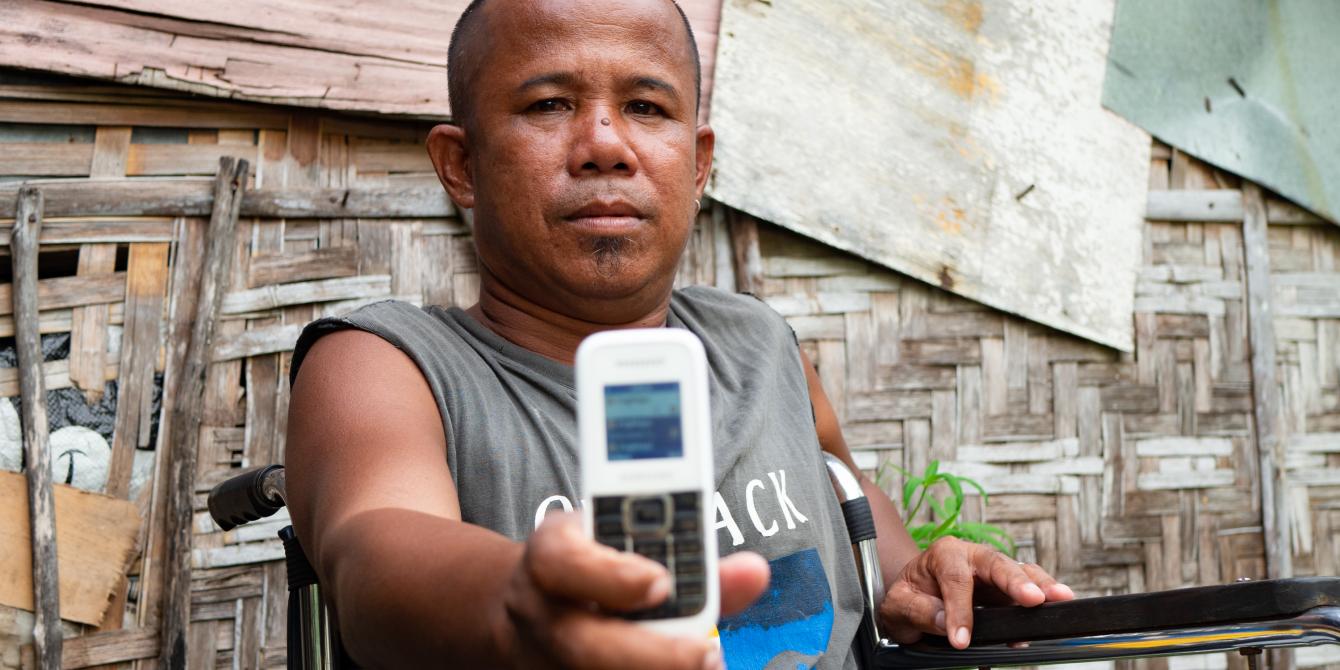 For Robert Escobar, phone transactions enable access to aid that might otherwise be beyond his reach. Photo: Elizabeth Stevens/Oxfam America For Robert Escobar, phone transactions enable access to aid that might otherwise be beyond his reach. Photo: Elizabeth Stevens/Oxfam America