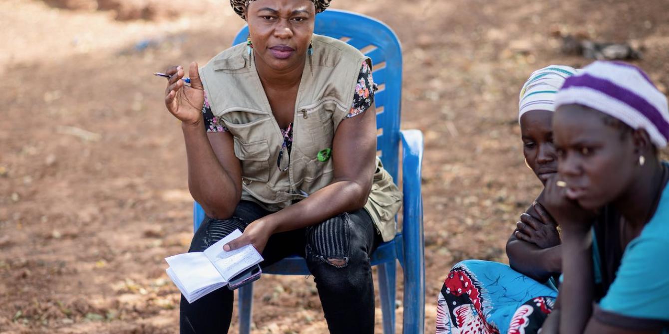 An Oxfam employee in Burkina Faso chats with displaced women. Credit: Sylvain Cherkaoui / Oxfam